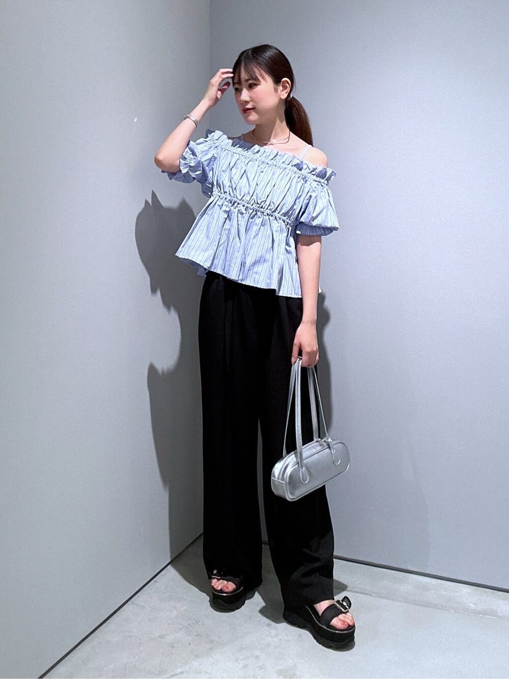 ブルー系のシャツ/ブラウス、ブラック系のその他パンツ、シルバー系のハンドバッグを着用したレディースの夏コーディネートの4枚目の写真