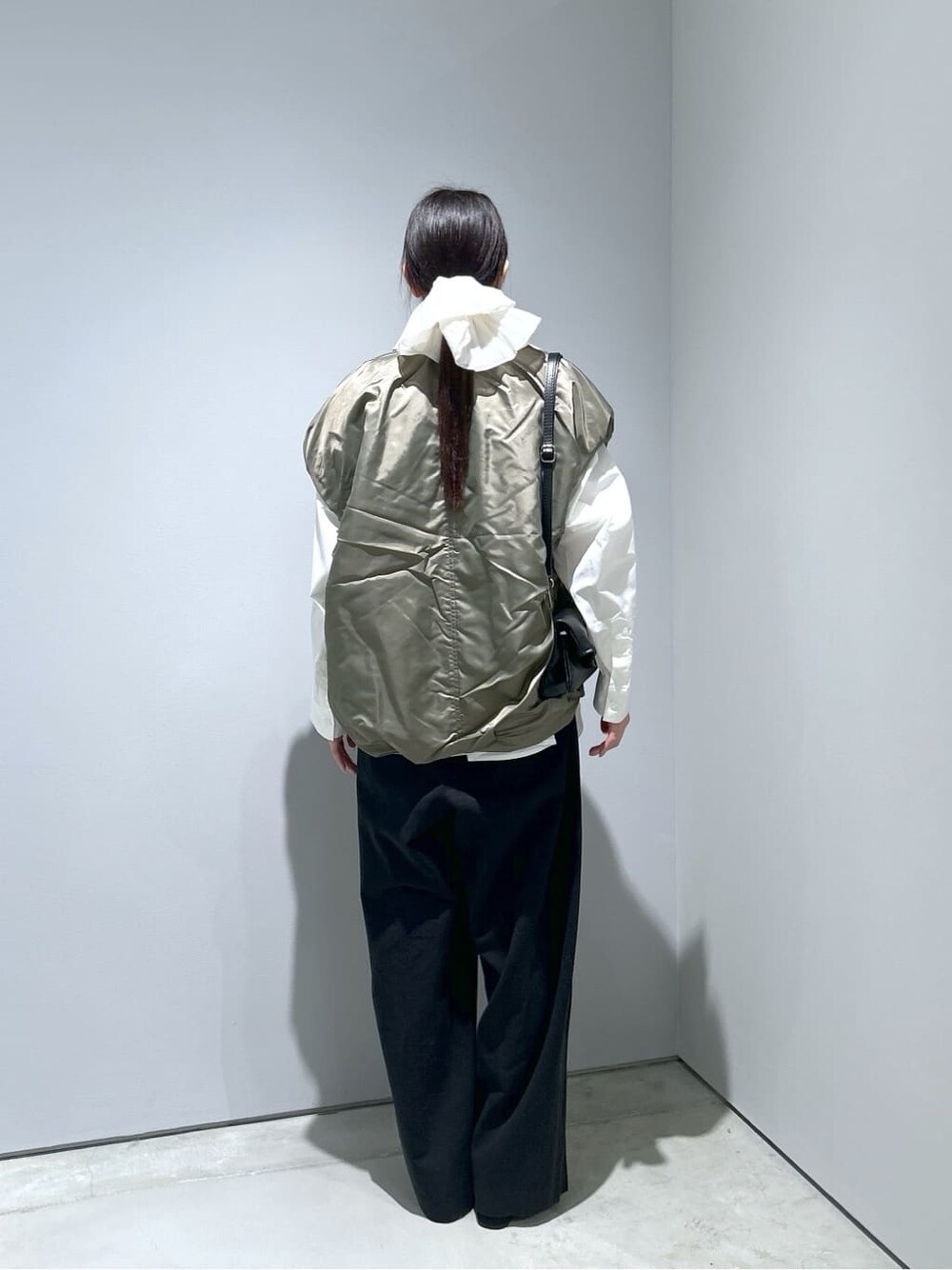 グリーン系のブルゾン、ホワイト系のシャツ/ブラウス、ブラック系のその他パンツを着用したレディースの冬コーディネートの5枚目の写真