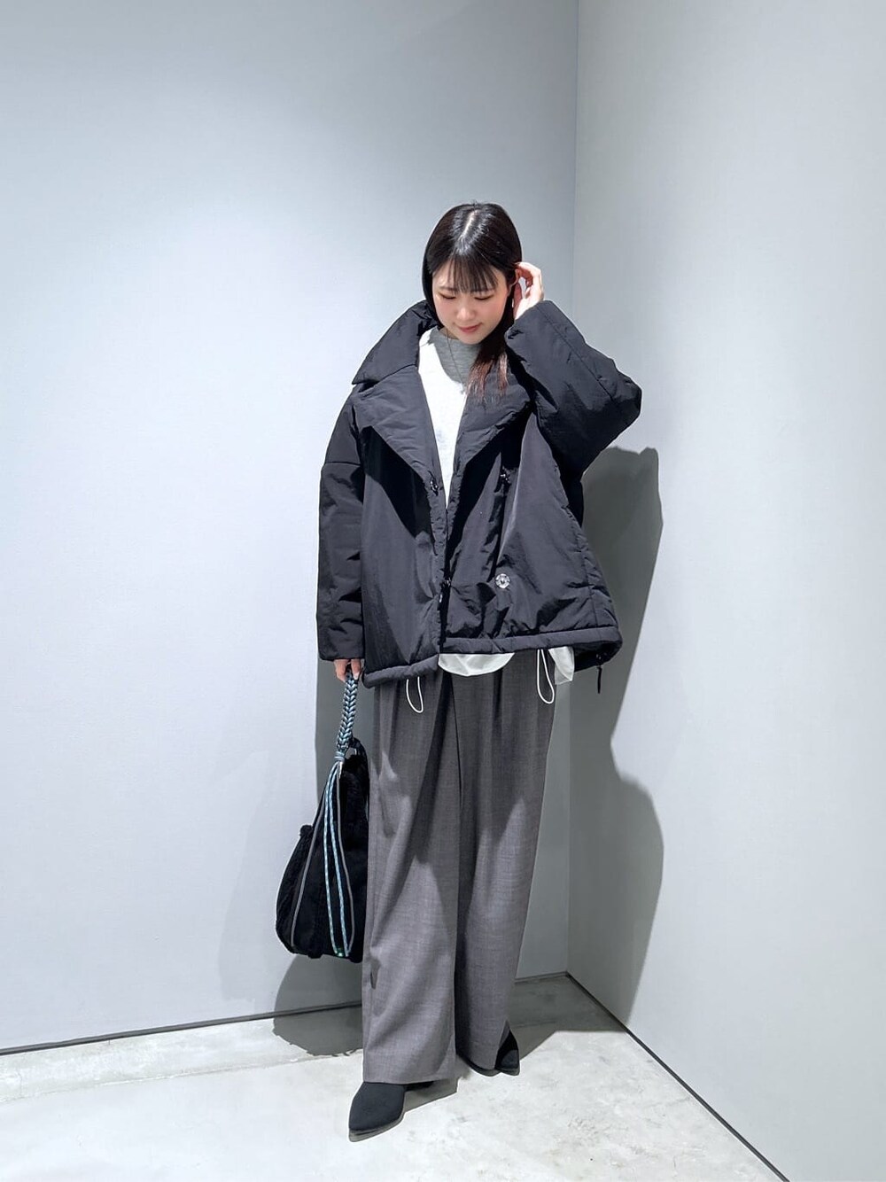 ブラック系のその他アウター、グレー系のその他パンツ、ブラック系のハンドバッグを着用したレディースの秋コーディネートの4枚目の写真
