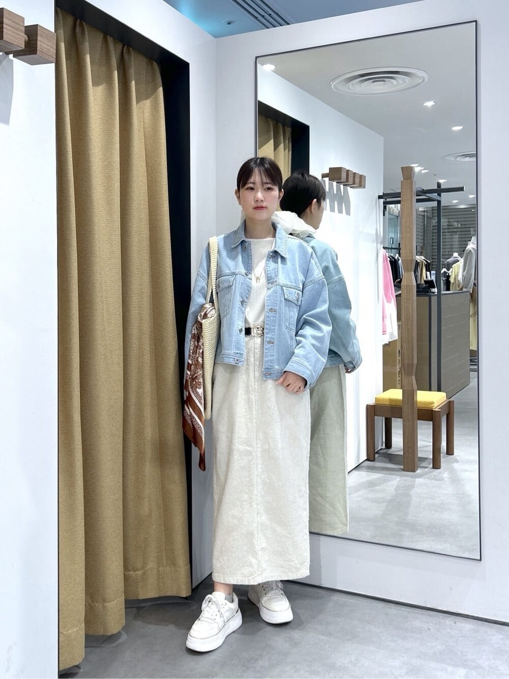 ブルー系のデニムジャケット、ホワイト系のTシャツ/カットソー、ホワイト系のスカートを着用したレディースの春コーディネートの2枚目の写真