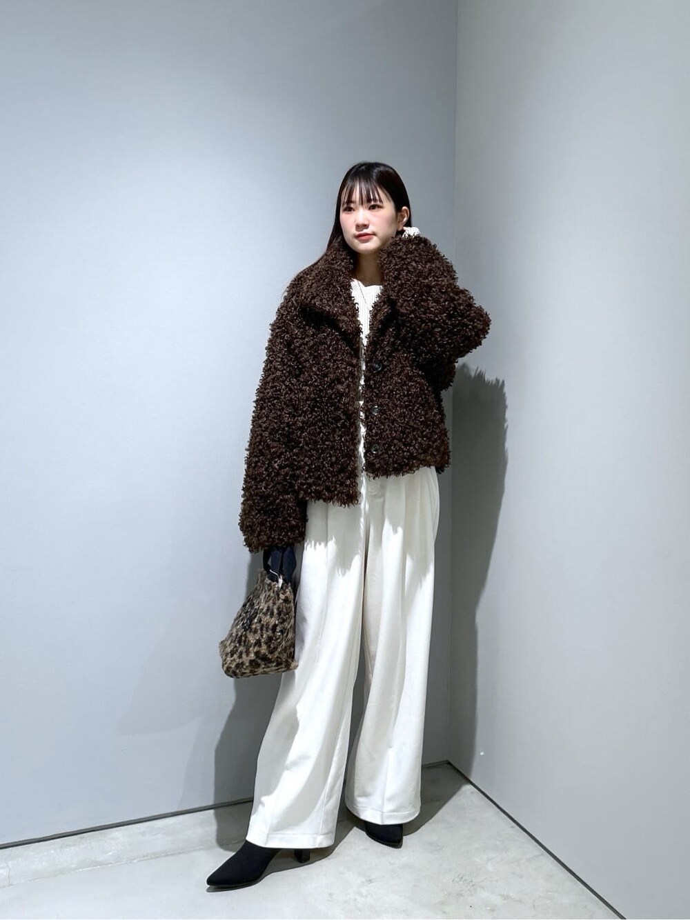 ブラウン系のブルゾン、ホワイト系のニット/セーター、ホワイト系のその他パンツを着用したレディースの秋コーディネートの2枚目の写真