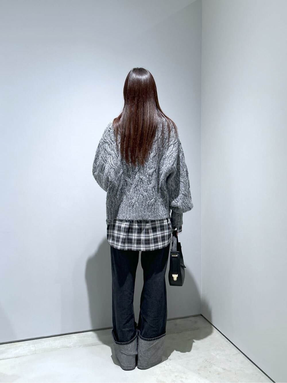 グレー系のニット/セーター、ブラック系のシャツ/ブラウス、グレー系のデニムパンツを着用したレディースの冬コーディネートの5枚目の写真