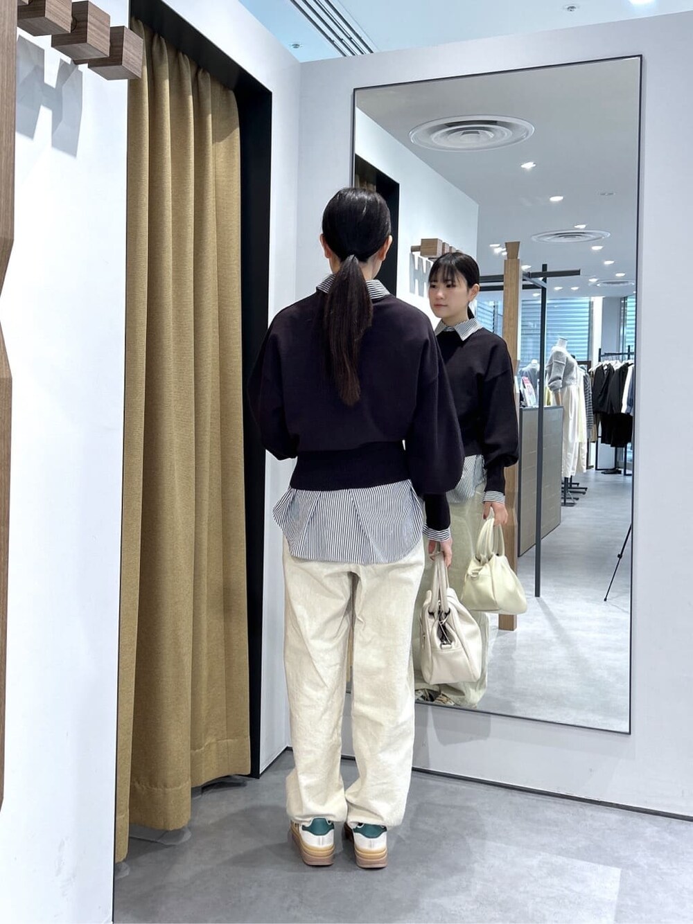 ブラック系のニット/セーター、ブラック系のシャツ/ブラウス、ホワイト系のその他パンツを着用したレディースの春コーディネートの6枚目の写真