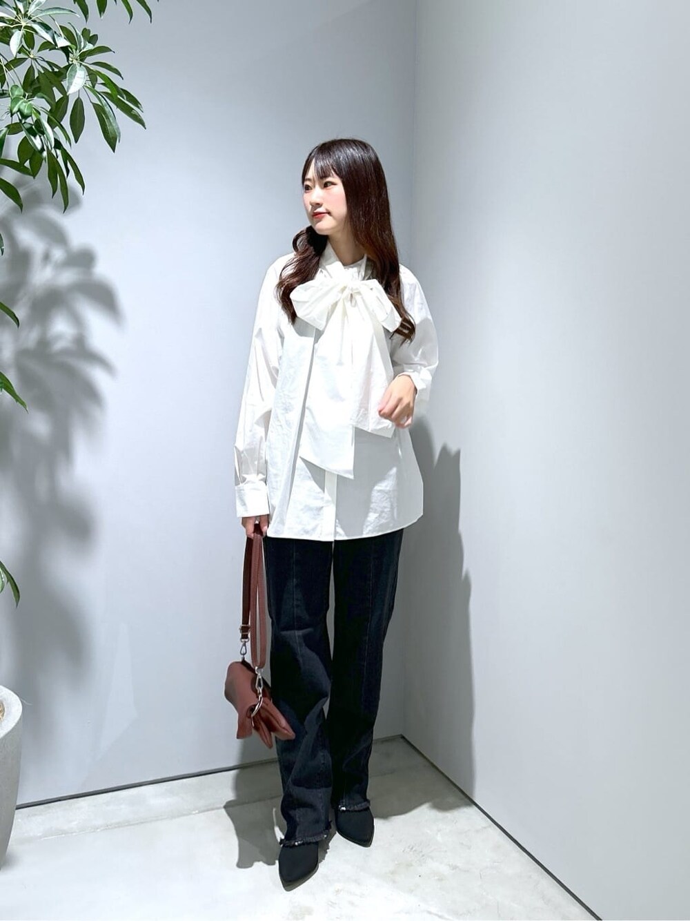ホワイト系のシャツ/ブラウス、グレー系のデニムパンツ、ブラウン系のショルダーバッグを着用したレディースの秋コーディネートの4枚目の写真