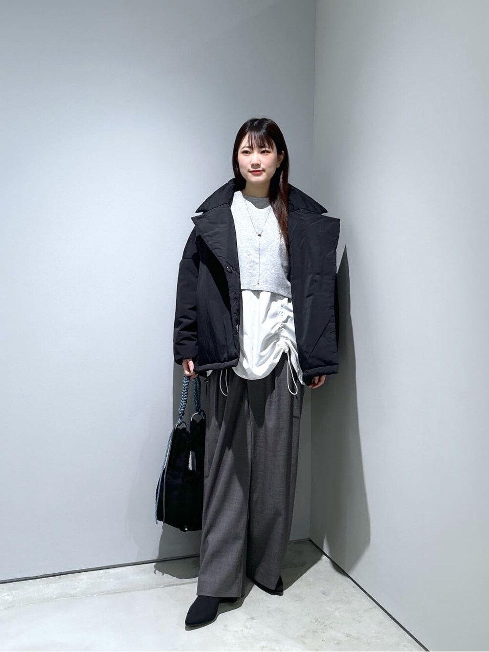 ブラック系のその他アウター、グレー系のその他パンツ、ブラック系のハンドバッグを着用したレディースの秋コーディネートの3枚目の写真