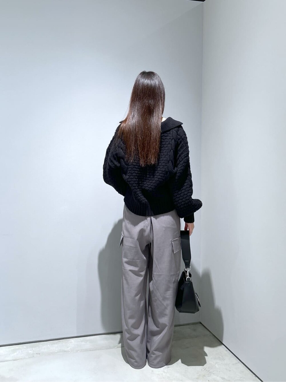 ブラック系のニット/セーター、グレー系のその他パンツ、ブラック系のショルダーバッグを着用したレディースの秋コーディネートの5枚目の写真