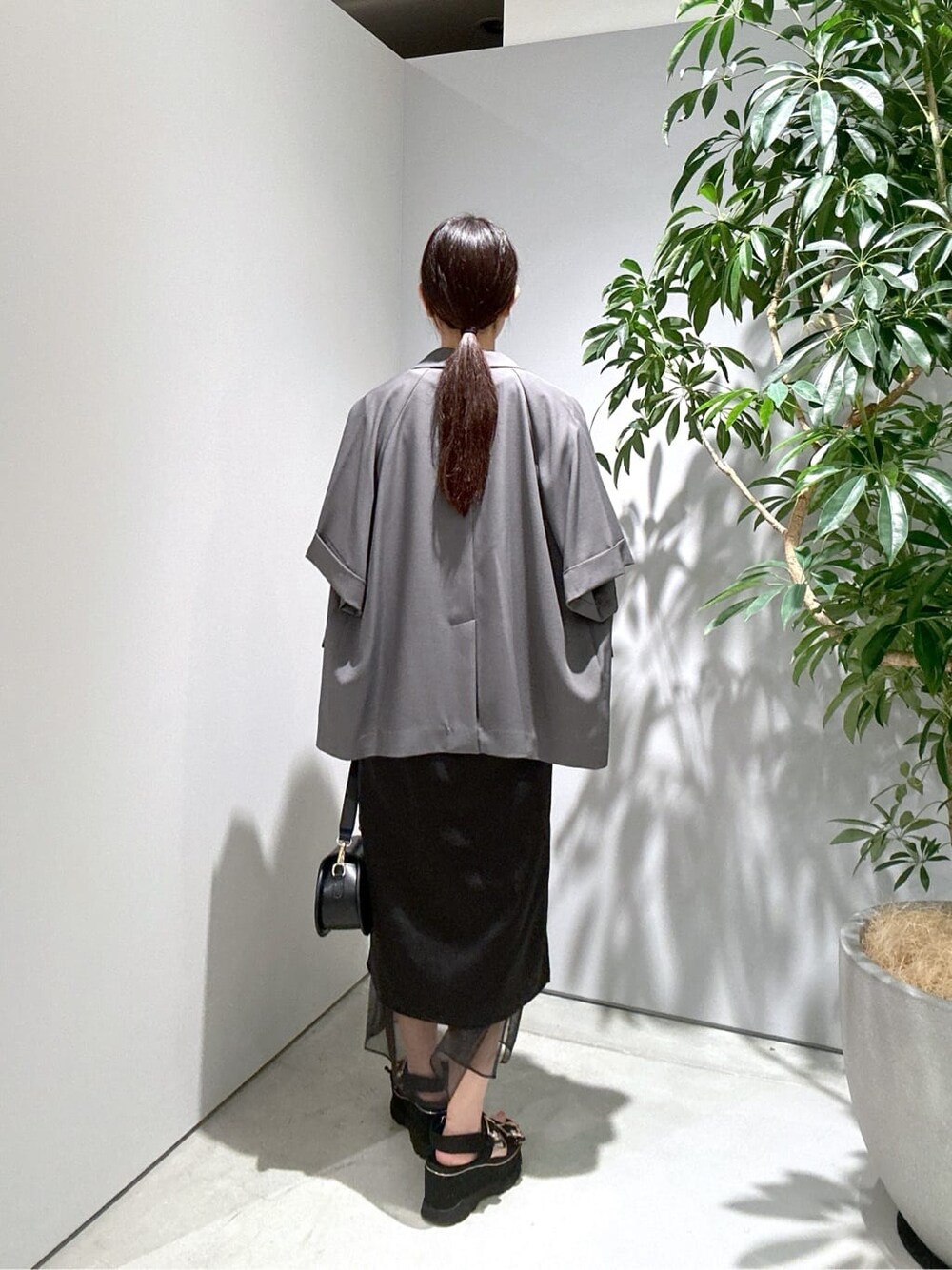 グレー系のテーラードジャケット、ホワイト系のTシャツ/カットソー、ブラック系のスカートを着用したレディースの夏コーディネートの5枚目の写真