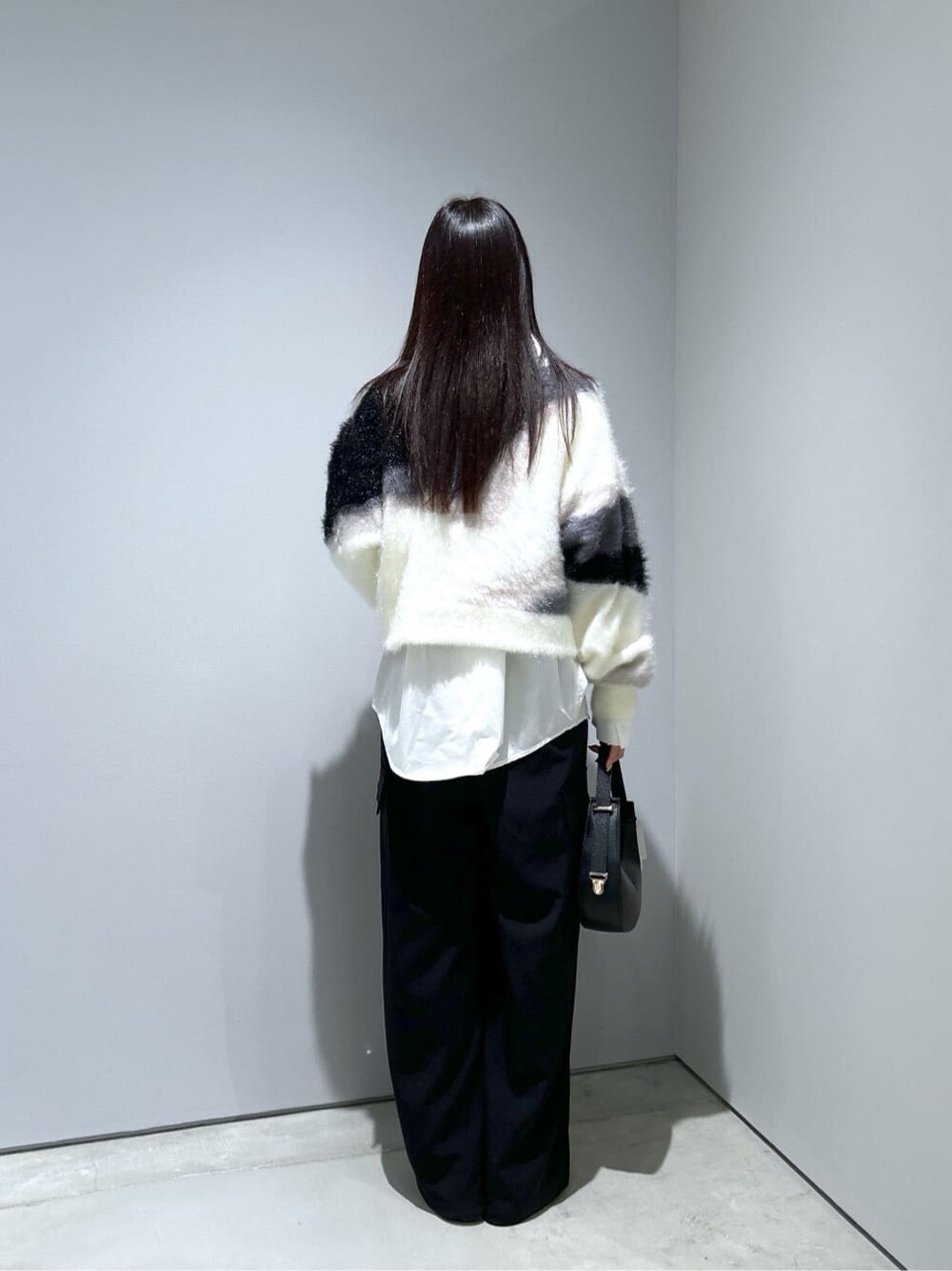 ホワイト系のニット/セーター、ホワイト系のシャツ/ブラウス、ブラック系のその他パンツを着用したレディースの冬コーディネートの5枚目の写真