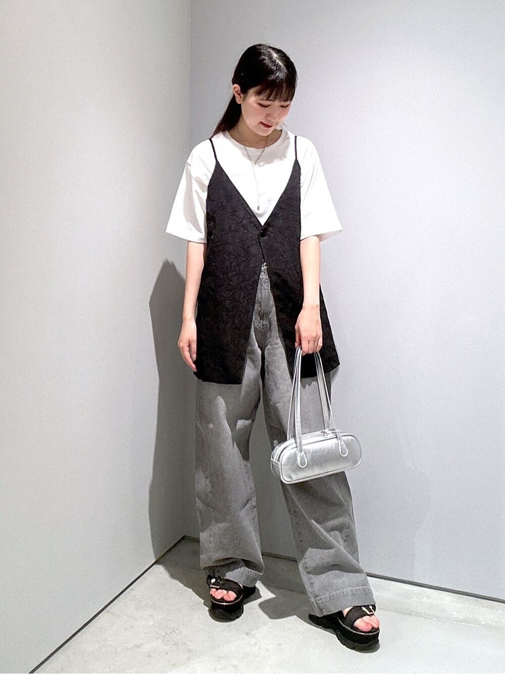 ホワイト系のTシャツ/カットソー、ブラック系のベスト、グレー系のデニムパンツを着用したレディースの夏コーディネートの5枚目の写真