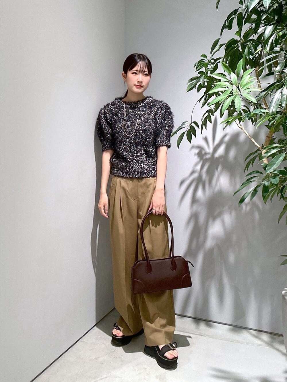 ブラック系のニット/セーター、イエロー系のその他パンツ、ブラウン系のショルダーバッグを着用したレディースの秋コーディネートの2枚目の写真