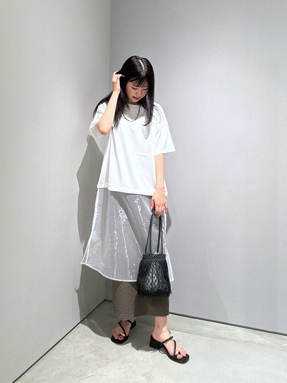 ホワイト系のTシャツ/カットソー、グリーン系のスカート、ブラック系のハンドバッグを着用したレディースの夏コーディネートの5枚目の写真