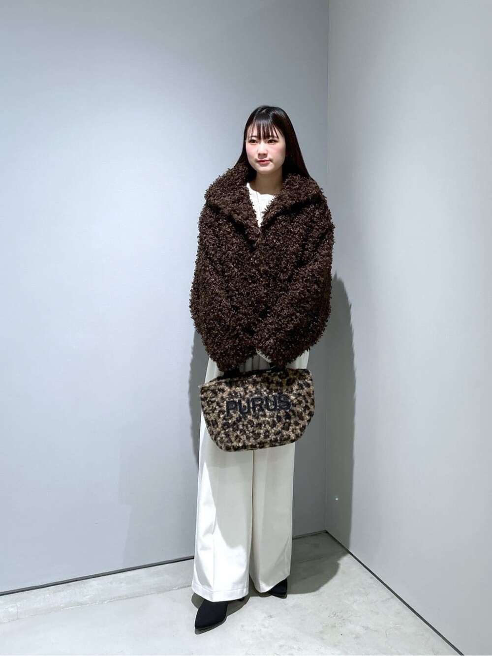 ブラウン系のブルゾン、ホワイト系のニット/セーター、ホワイト系のその他パンツを着用したレディースの秋コーディネートの3枚目の写真