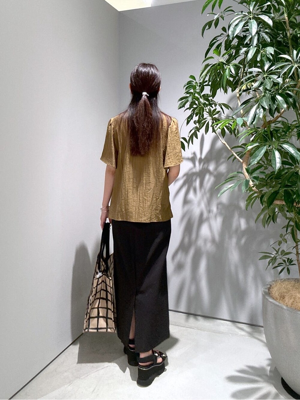 グリーン系のシャツ/ブラウス、ブラック系のスカート、ベージュ系のトートバッグを着用したレディースの夏コーディネートの5枚目の写真