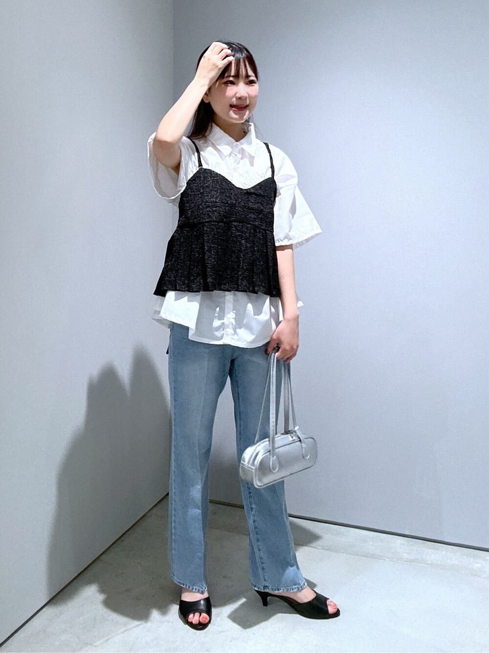 ホワイト系のシャツ/ブラウス、ブルー系のデニムパンツ、シルバー系のハンドバッグを着用したレディースの夏コーディネートの3枚目の写真