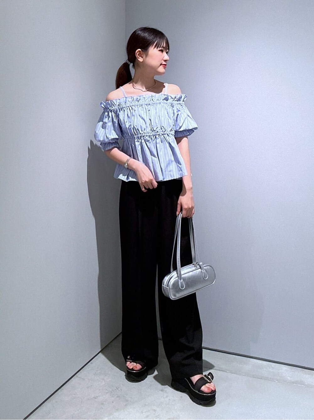 ブルー系のシャツ/ブラウス、ブラック系のその他パンツ、シルバー系のハンドバッグを着用したレディースの夏コーディネートの3枚目の写真