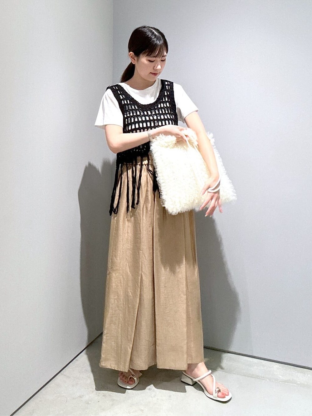 ホワイト系のTシャツ/カットソー、イエロー系のスカート、ホワイト系のサンダルを着用したレディースの夏コーディネートの4枚目の写真