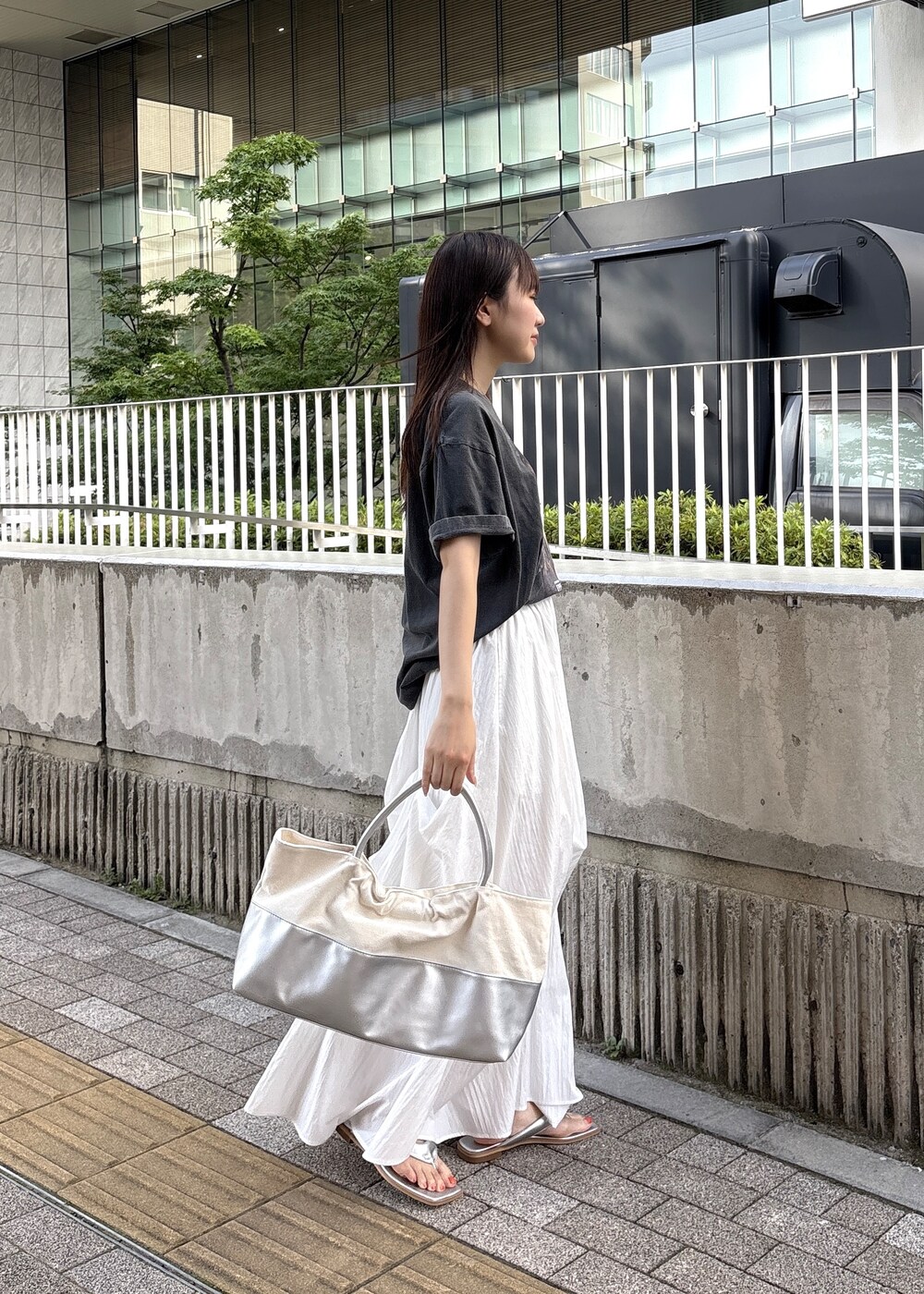シルバー系のサンダル、グレー系のTシャツ/カットソー、シルバー系のトートバッグを着用したレディースの春コーディネートの3枚目の写真