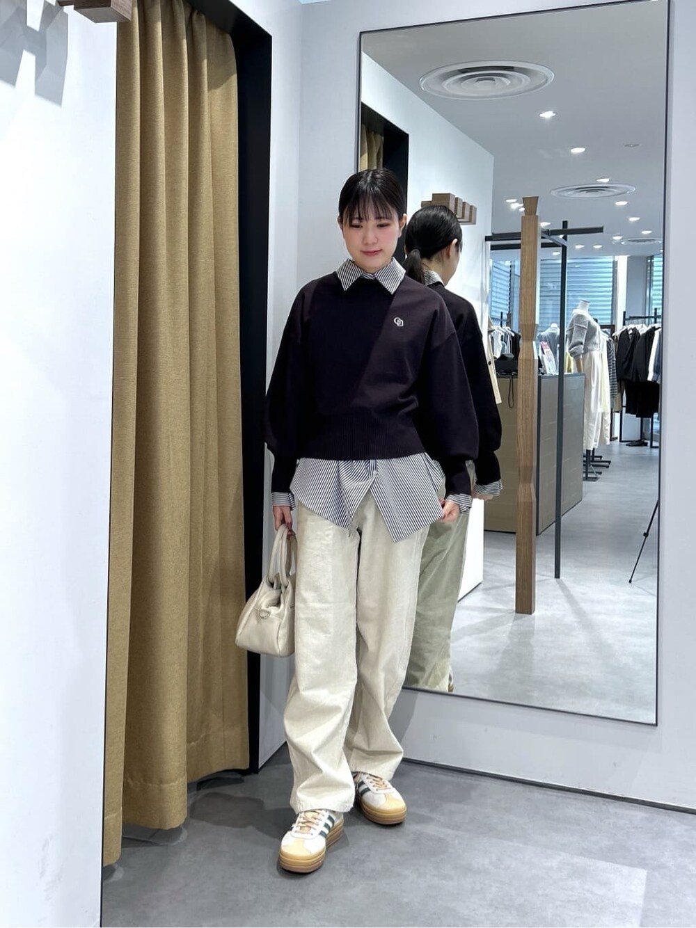 ブラック系のニット/セーター、ブラック系のシャツ/ブラウス、ホワイト系のその他パンツを着用したレディースの春コーディネートの4枚目の写真