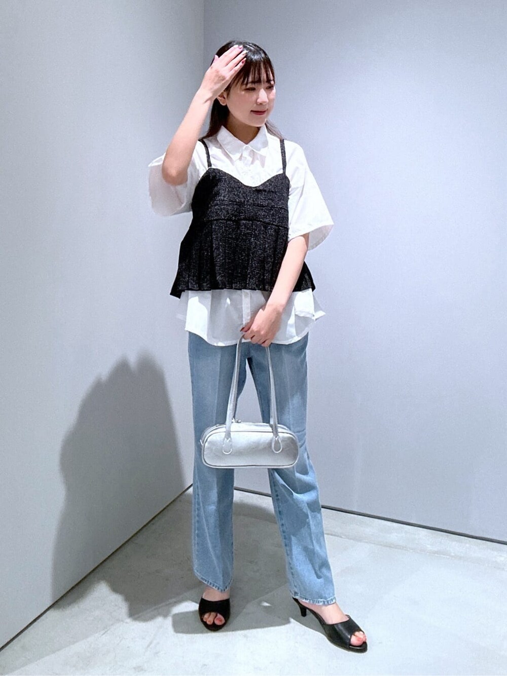 ホワイト系のシャツ/ブラウス、ブルー系のデニムパンツ、シルバー系のハンドバッグを着用したレディースの夏コーディネートの2枚目の写真