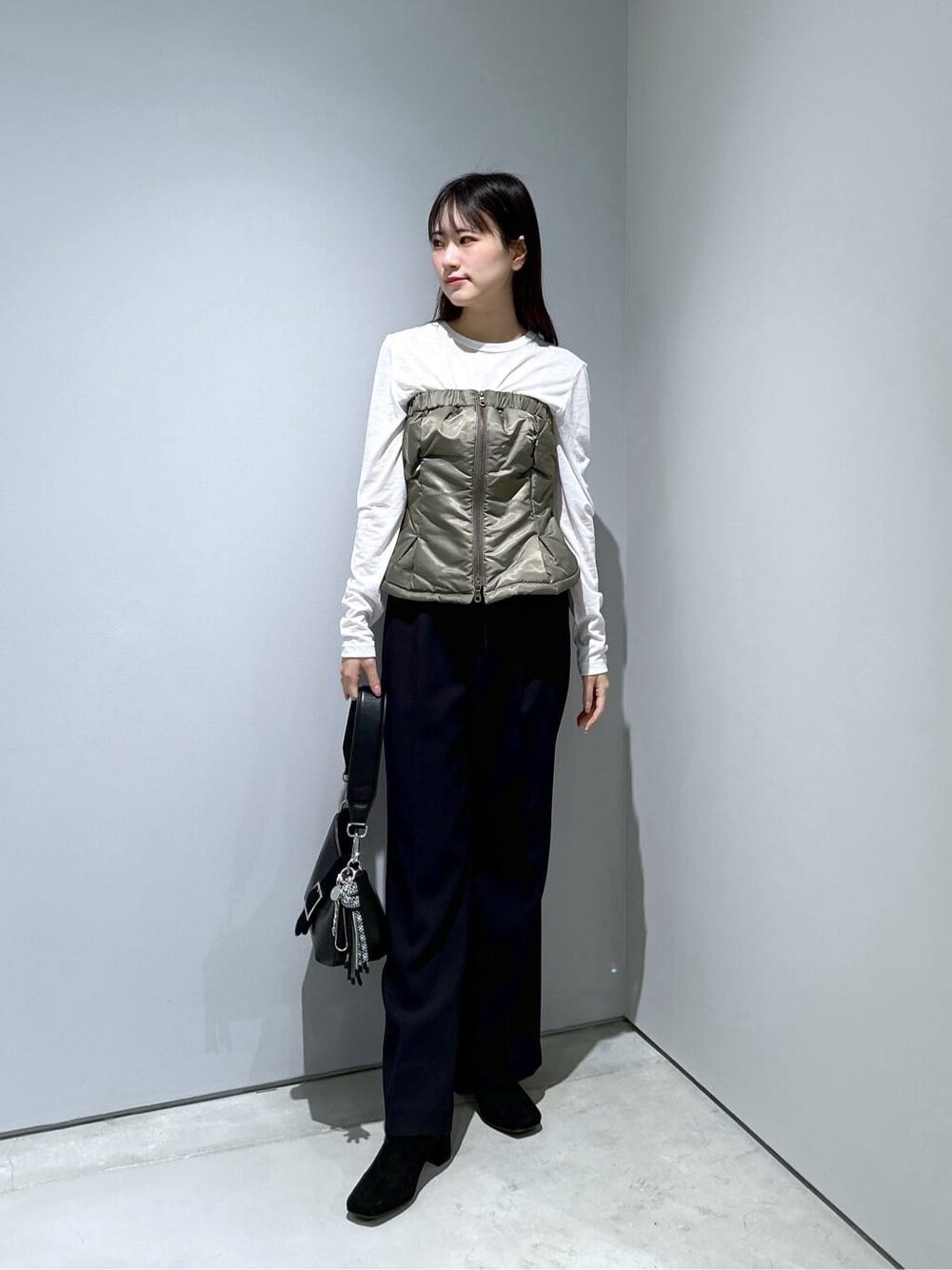 グリーン系のその他アウター、ホワイト系のTシャツ/カットソー、ブラック系のその他パンツを着用したレディースの冬コーディネートの2枚目の写真