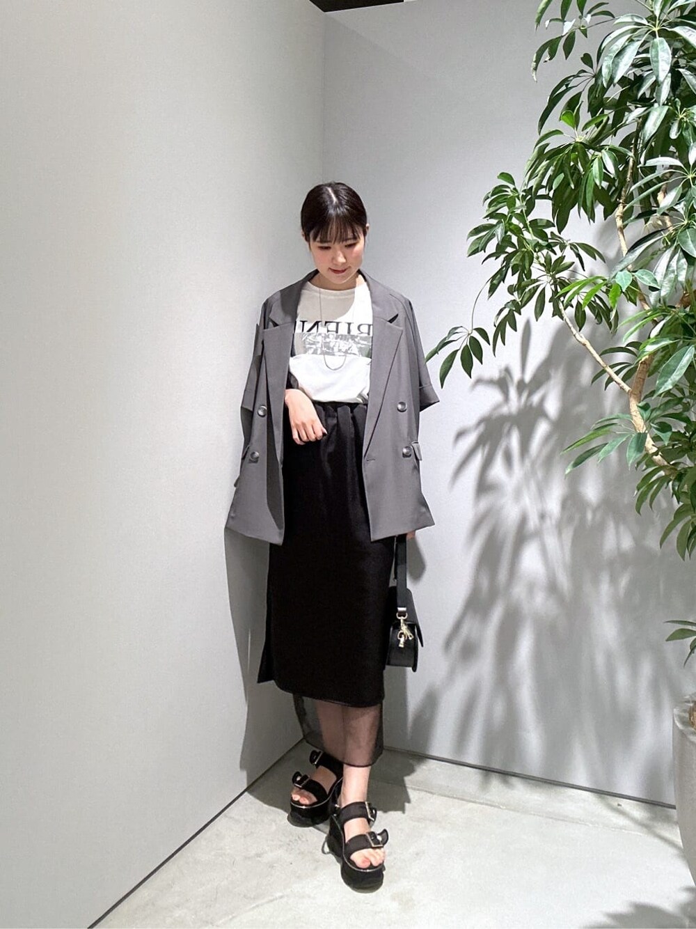 グレー系のテーラードジャケット、ホワイト系のTシャツ/カットソー、ブラック系のスカートを着用したレディースの夏コーディネートの4枚目の写真