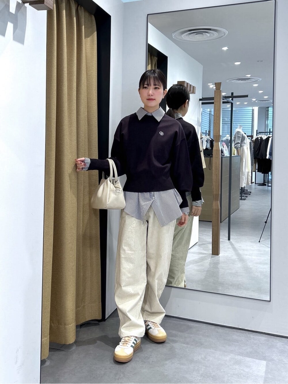 ブラック系のニット/セーター、ブラック系のシャツ/ブラウス、ホワイト系のその他パンツを着用したレディースの春コーディネートの2枚目の写真