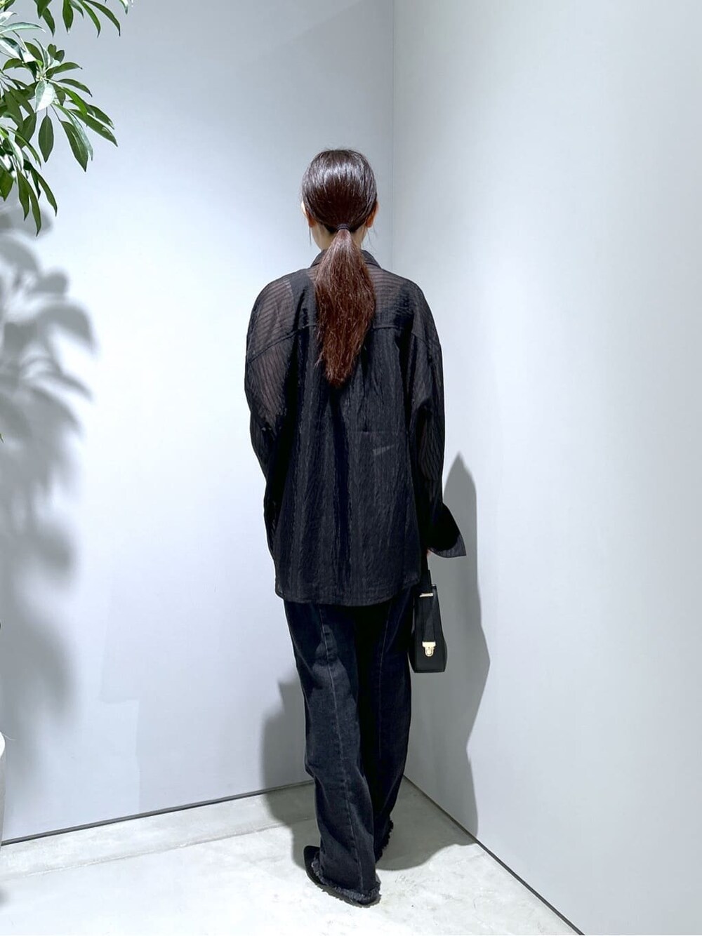 ブラック系のシャツ/ブラウス、グレー系のデニムパンツ、ブラック系のショルダーバッグを着用したレディースの秋コーディネートの5枚目の写真