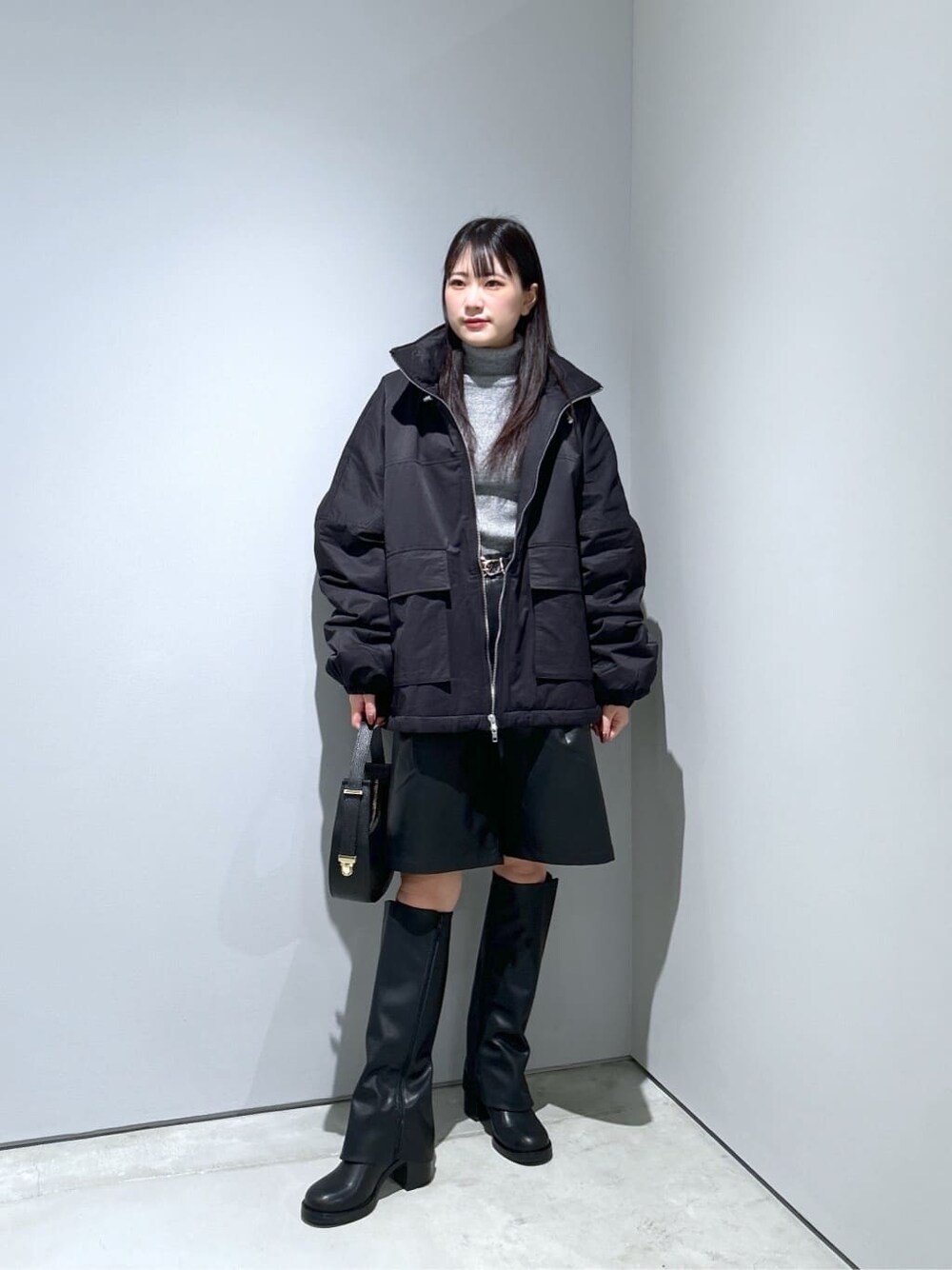 ブラック系のその他アウター、グレー系のニット/セーター、ブラック系のその他パンツを着用したレディースの冬コーディネートの3枚目の写真