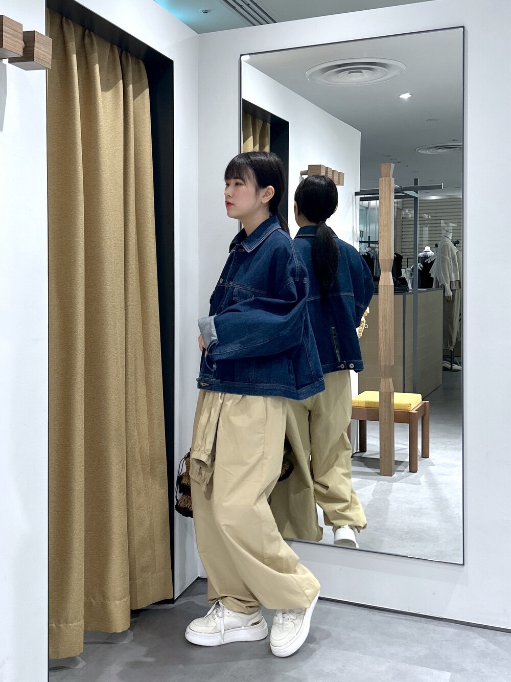 ブルー系のデニムジャケット、ホワイト系のニット/セーター、ベージュ系のその他パンツを着用したレディースの春コーディネートの5枚目の写真