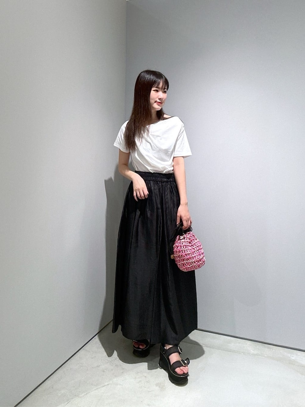 ホワイト系のTシャツ/カットソー、ブラック系のスカート、ピンク系のハンドバッグを着用したレディースの夏コーディネートの3枚目の写真