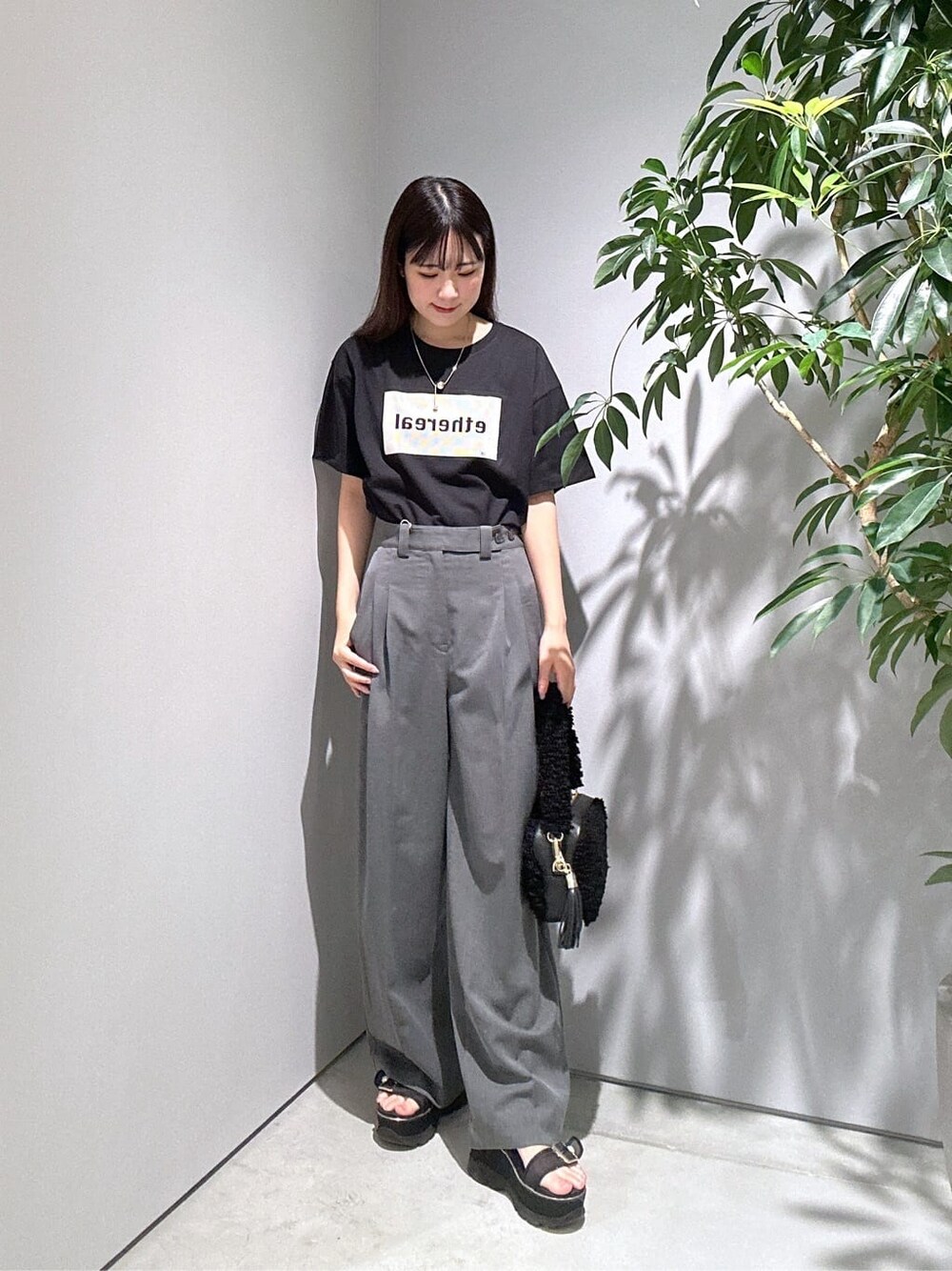 ブラック系のTシャツ/カットソー、グレー系のその他パンツ、ブラック系のハンドバッグを着用したレディースの夏コーディネートの4枚目の写真
