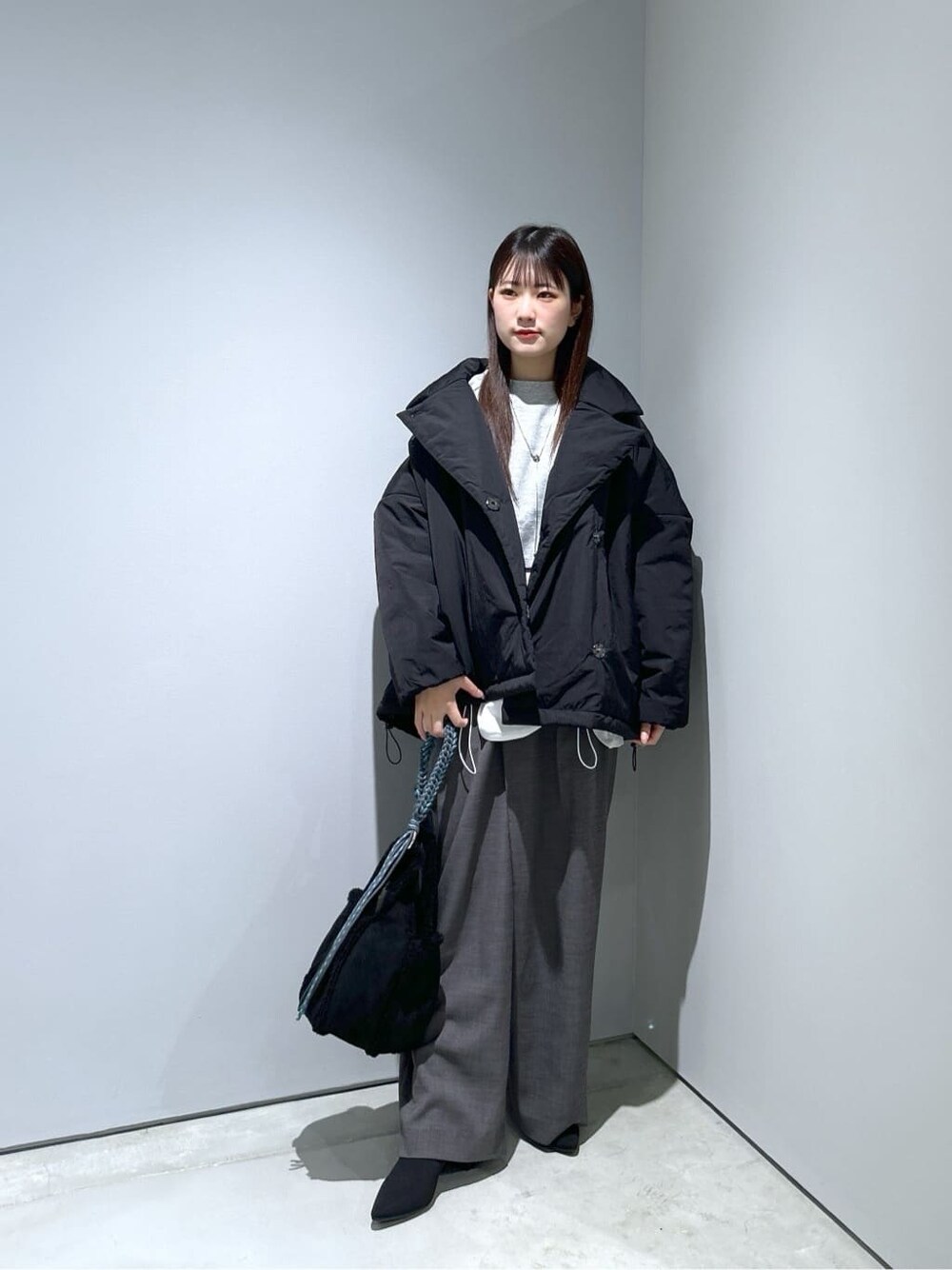ブラック系のその他アウター、グレー系のその他パンツ、ブラック系のハンドバッグを着用したレディースの秋コーディネートの2枚目の写真