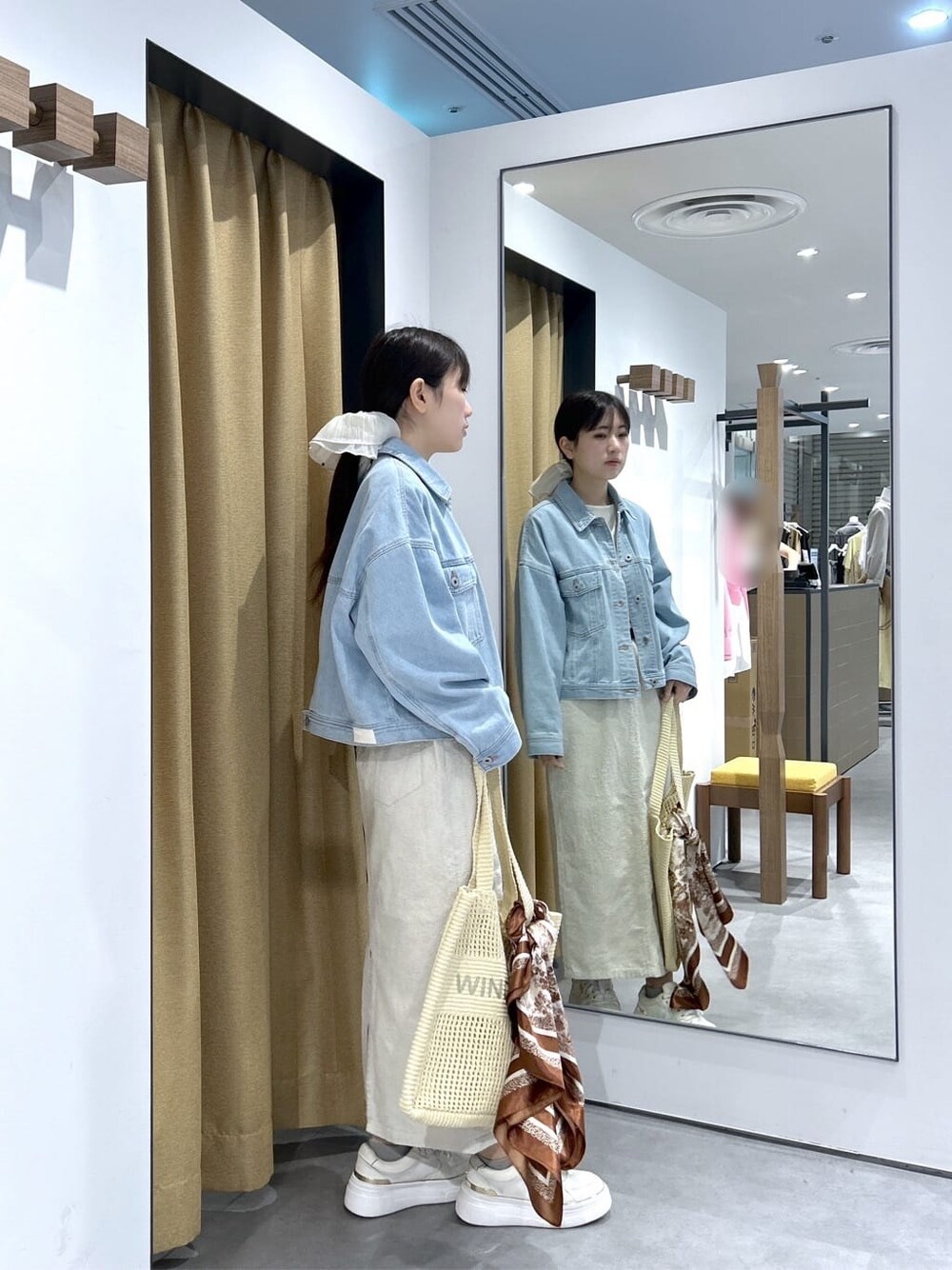 ブルー系のデニムジャケット、ホワイト系のTシャツ/カットソー、ホワイト系のスカートを着用したレディースの春コーディネートの5枚目の写真