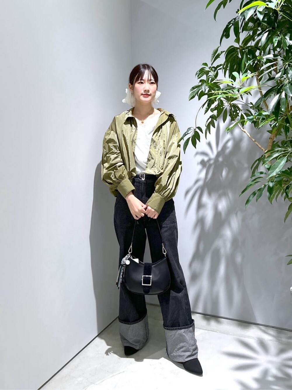 グリーン系のブルゾン、ホワイト系のTシャツ/カットソー、グレー系のデニムパンツを着用したレディースの秋コーディネートの2枚目の写真