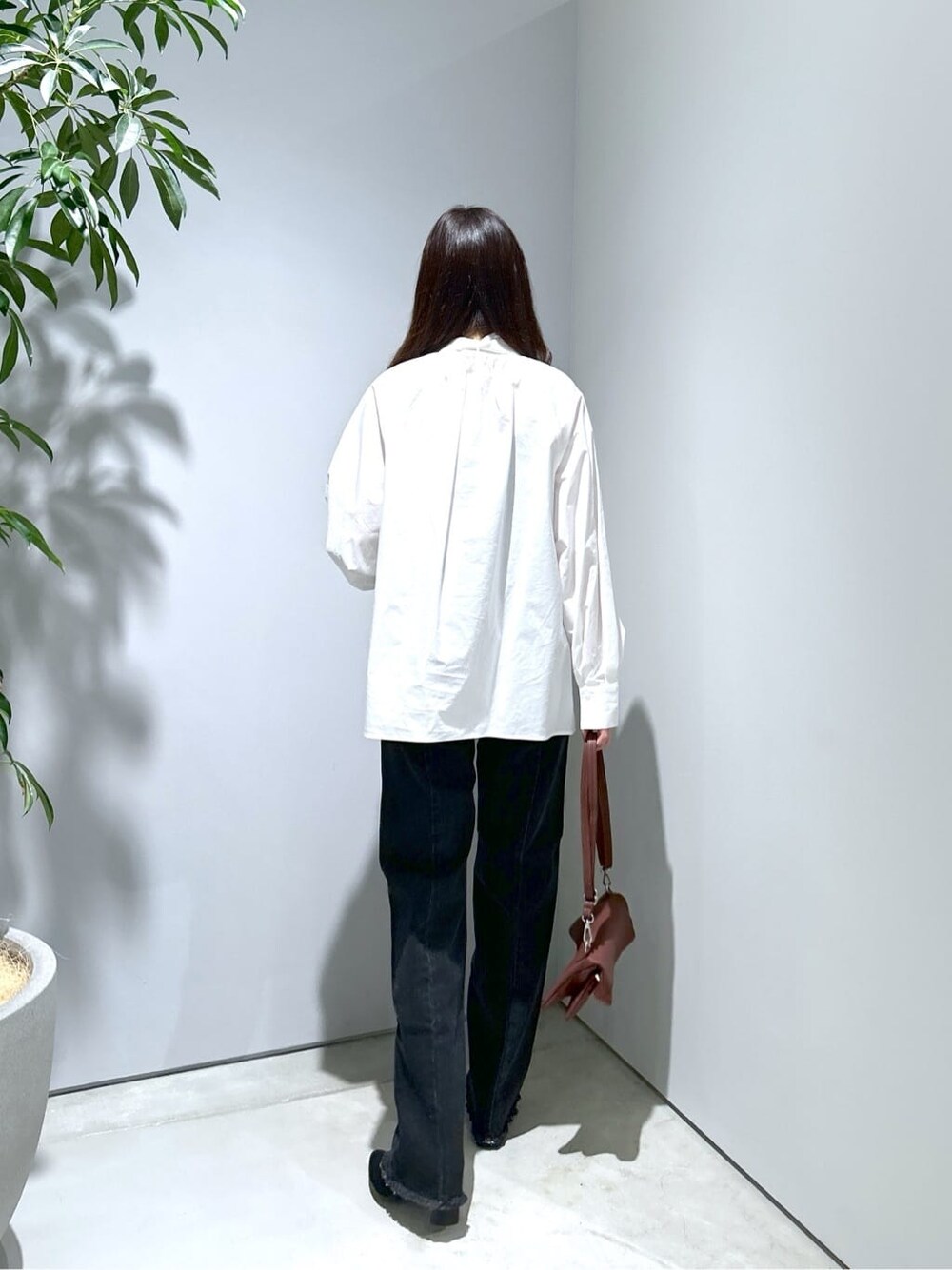 ホワイト系のシャツ/ブラウス、グレー系のデニムパンツ、ブラウン系のショルダーバッグを着用したレディースの秋コーディネートの6枚目の写真