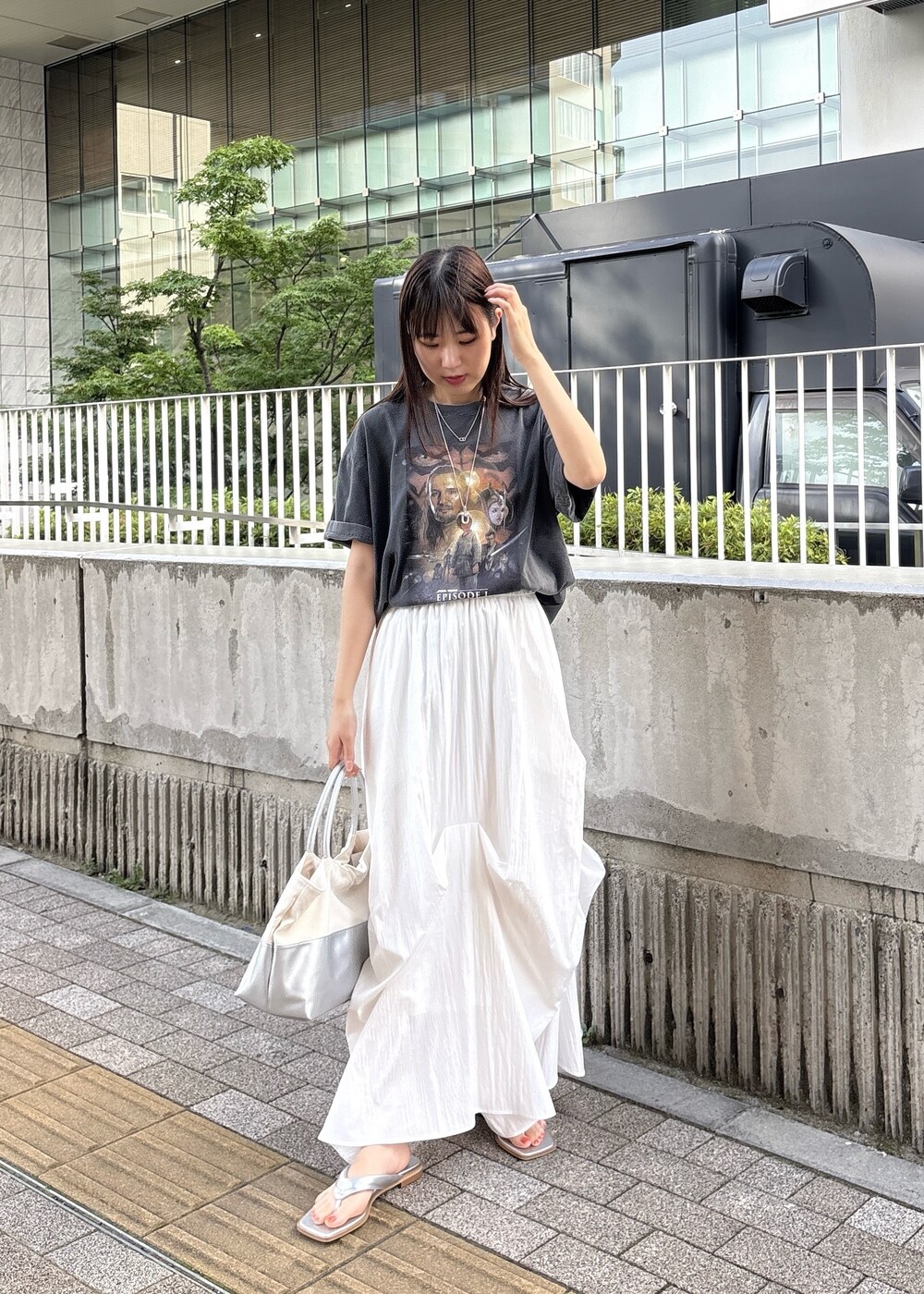 シルバー系のサンダル、グレー系のTシャツ/カットソー、シルバー系のトートバッグを着用したレディースの春コーディネートの2枚目の写真