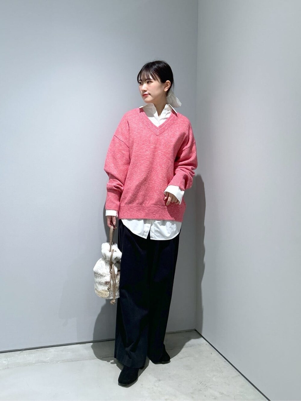 ピンク系のニット/セーター、ホワイト系のシャツ/ブラウス、ブラック系のその他パンツを着用したレディースの冬コーディネートの2枚目の写真