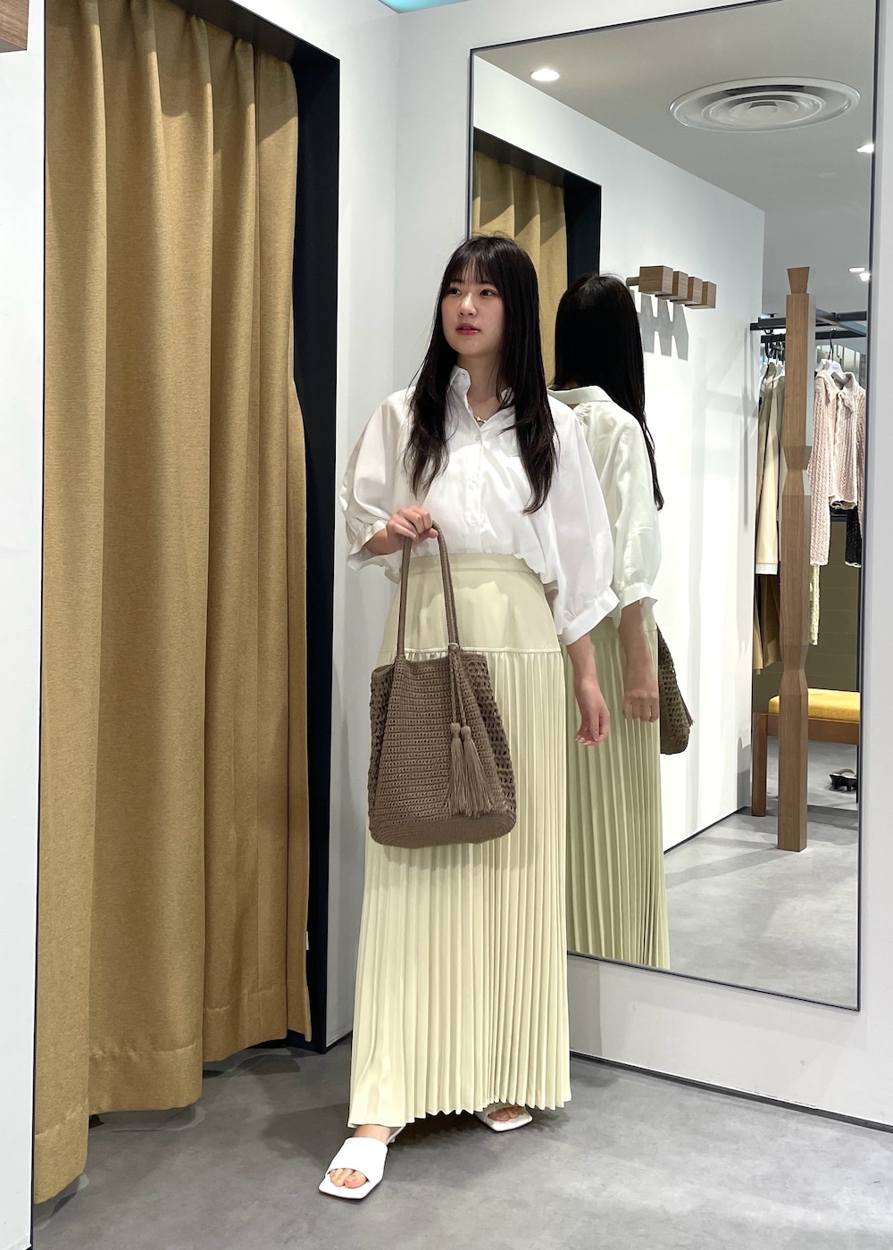 ホワイト系のシャツ/ブラウス、ホワイト系のタンクトップ、イエロー系のスカートを着用したレディースの春コーディネートの2枚目の写真