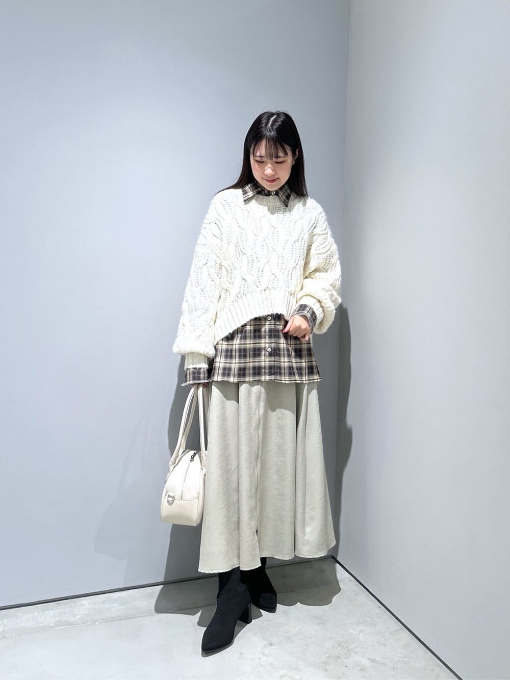 ホワイト系のニット/セーター、ベージュ系のシャツ/ブラウス、グリーン系のスカートを着用したレディースの冬コーディネートの4枚目の写真