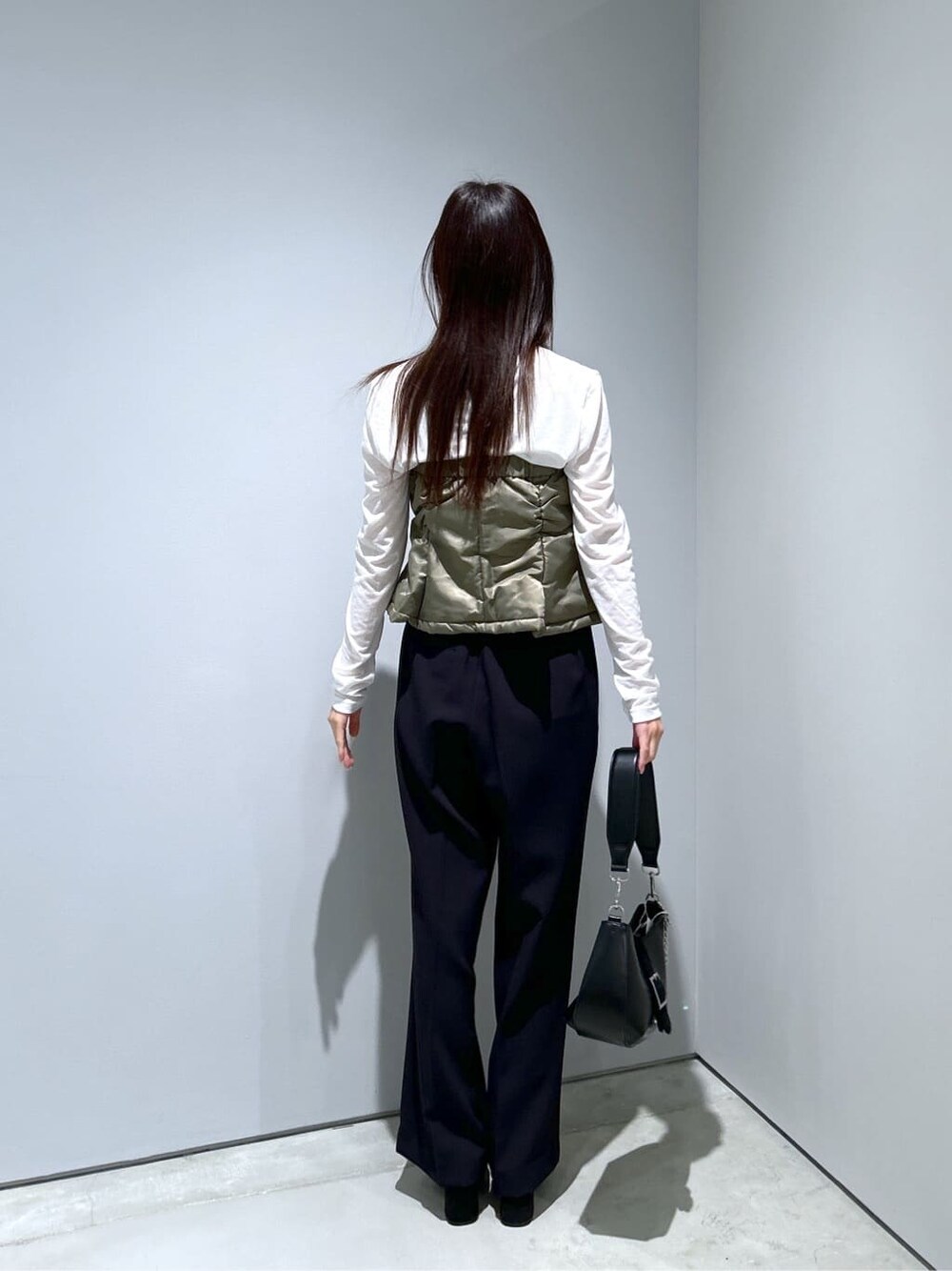 グリーン系のその他アウター、ホワイト系のTシャツ/カットソー、ブラック系のその他パンツを着用したレディースの冬コーディネートの5枚目の写真
