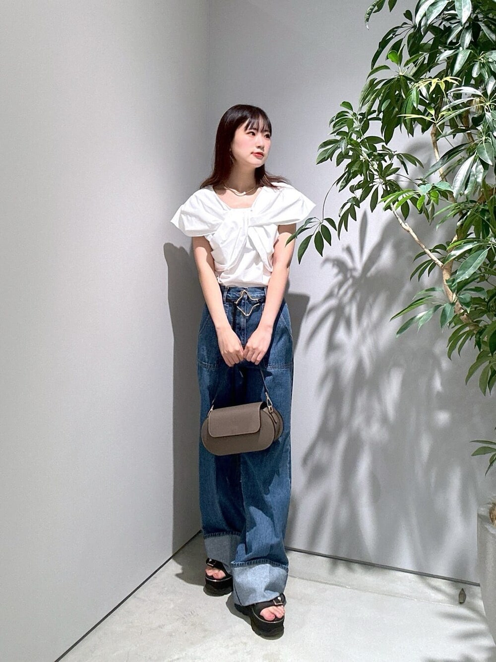 ホワイト系のシャツ/ブラウス、ブルー系のデニムパンツ、ゴールド系のネックレスを着用したレディースの夏コーディネートの3枚目の写真