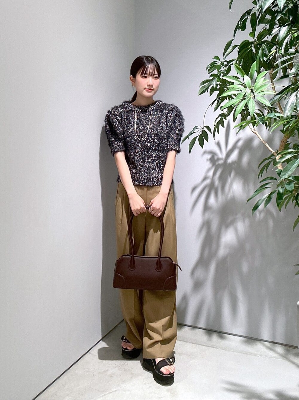 ブラック系のニット/セーター、イエロー系のその他パンツ、ブラウン系のショルダーバッグを着用したレディースの秋コーディネートの3枚目の写真
