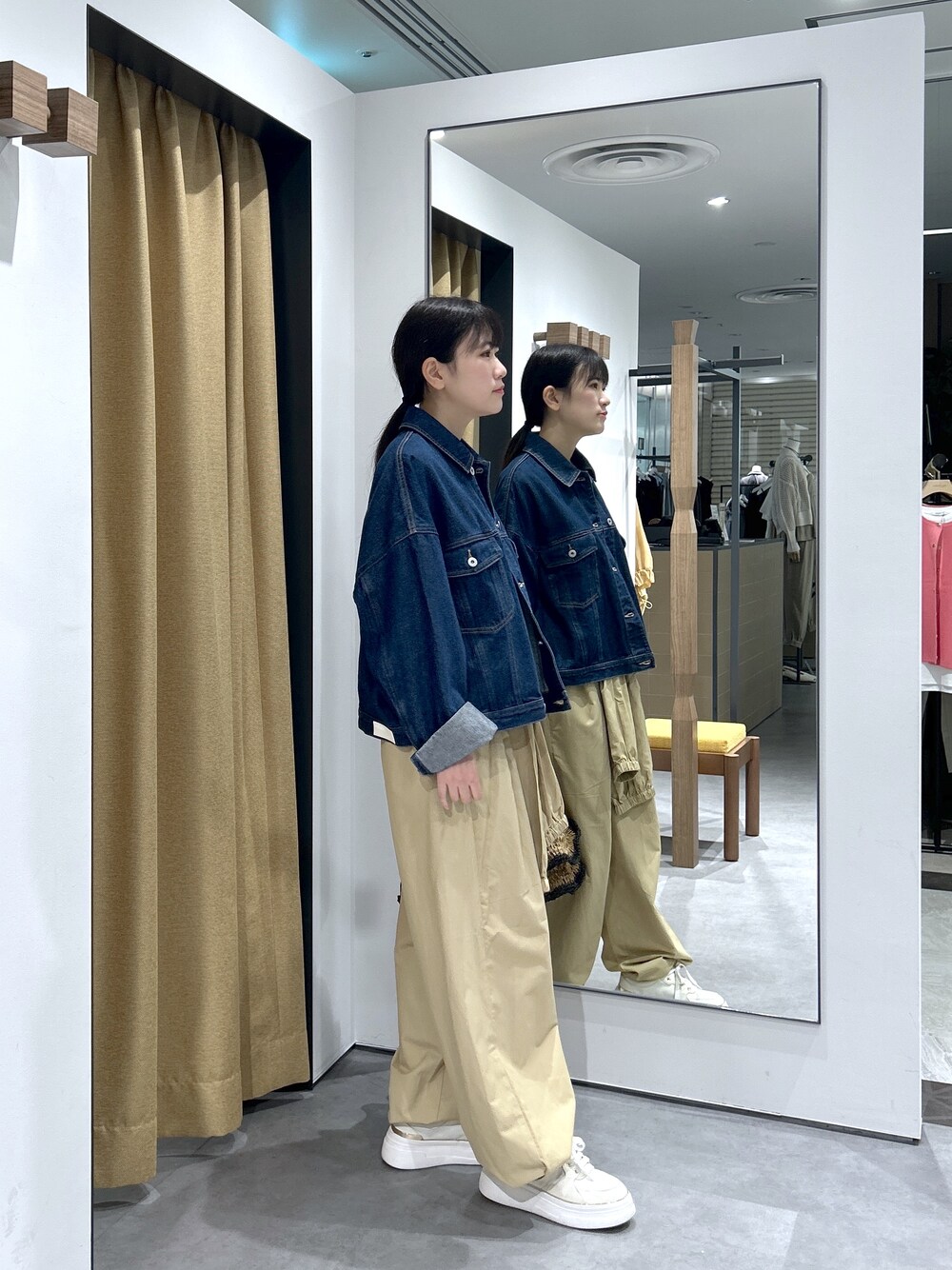 ブルー系のデニムジャケット、ホワイト系のニット/セーター、ベージュ系のその他パンツを着用したレディースの春コーディネートの4枚目の写真