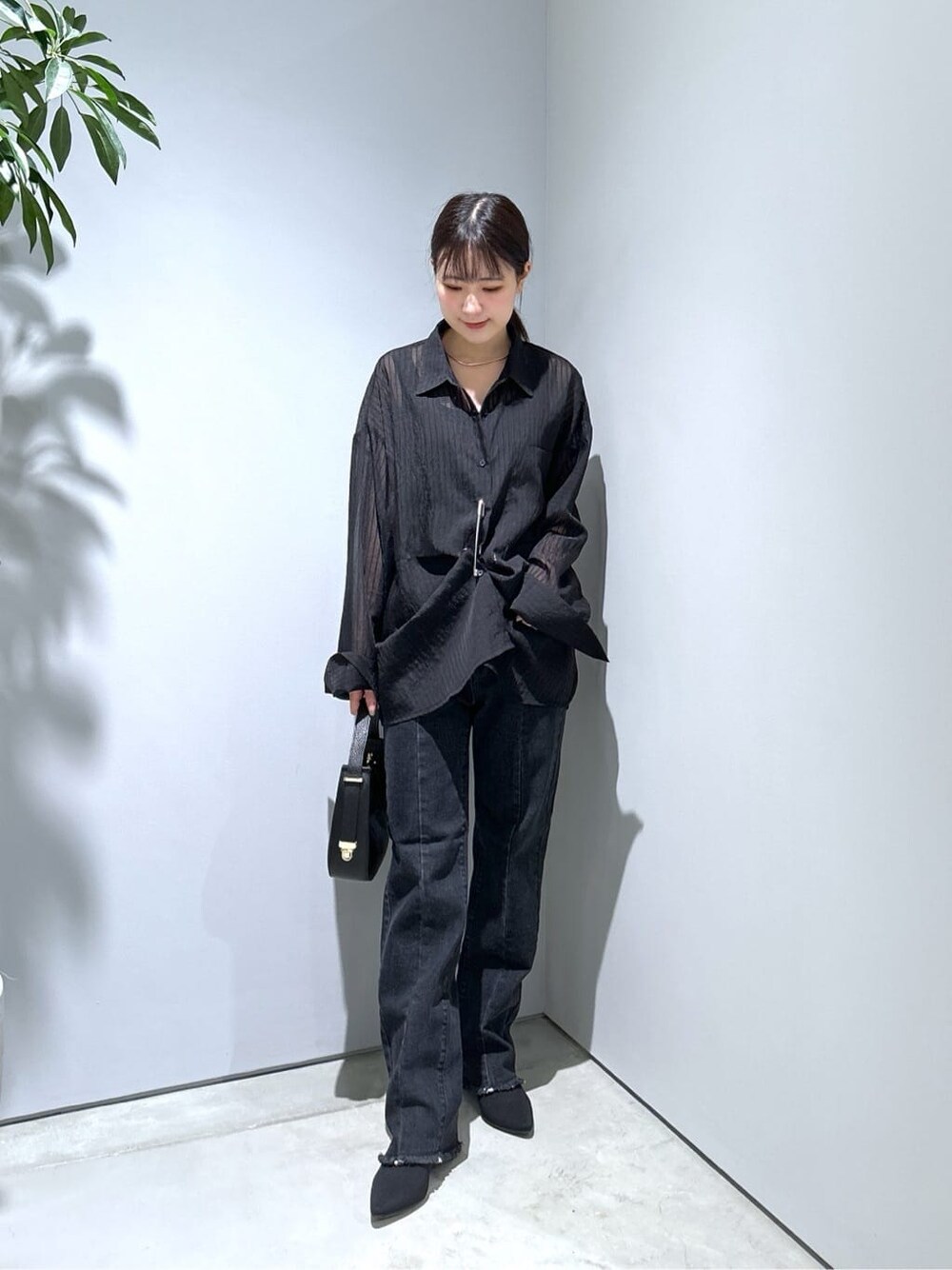 ブラック系のシャツ/ブラウス、グレー系のデニムパンツ、ブラック系のショルダーバッグを着用したレディースの秋コーディネートの4枚目の写真