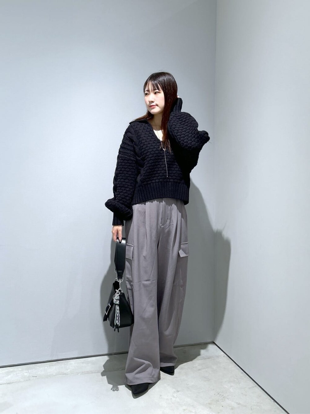ブラック系のニット/セーター、グレー系のその他パンツ、ブラック系のショルダーバッグを着用したレディースの秋コーディネートの3枚目の写真