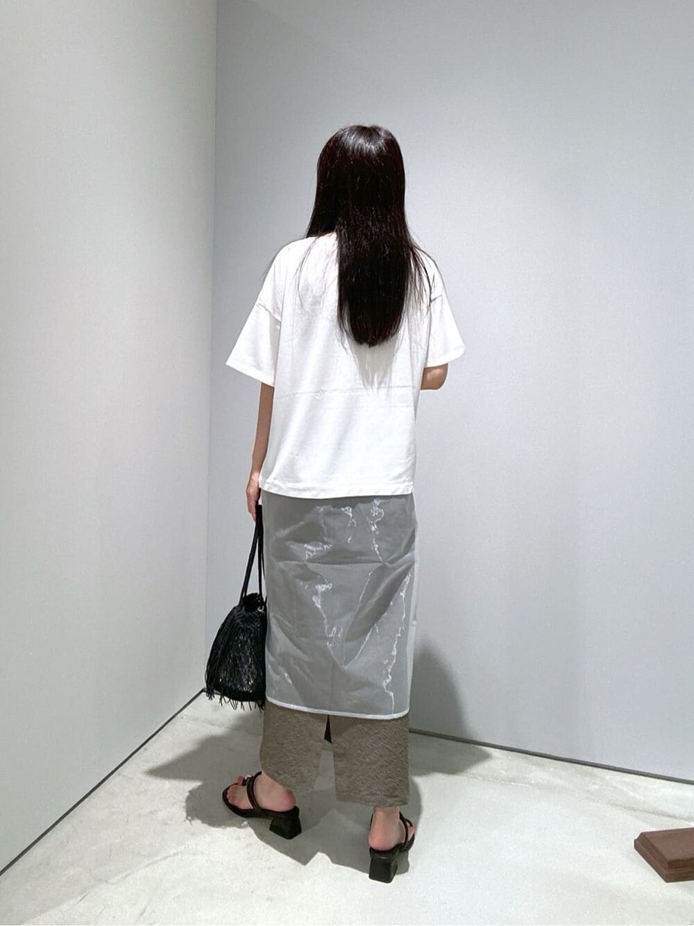 ホワイト系のTシャツ/カットソー、グリーン系のスカート、ブラック系のハンドバッグを着用したレディースの夏コーディネートの6枚目の写真