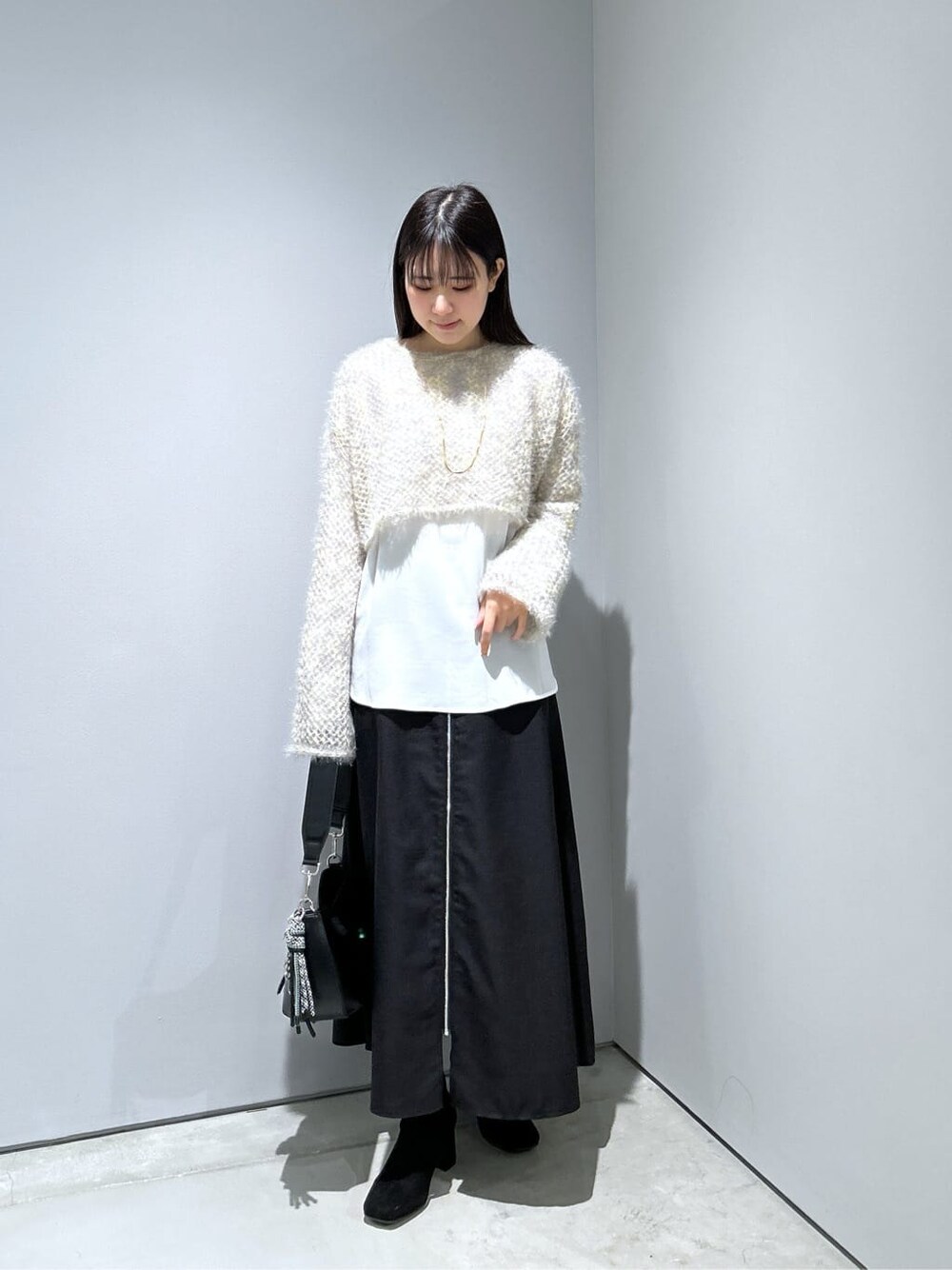 ベージュ系のニット/セーター、ホワイト系のシャツ/ブラウス、ブラック系のスカートを着用したレディースの冬コーディネートの4枚目の写真