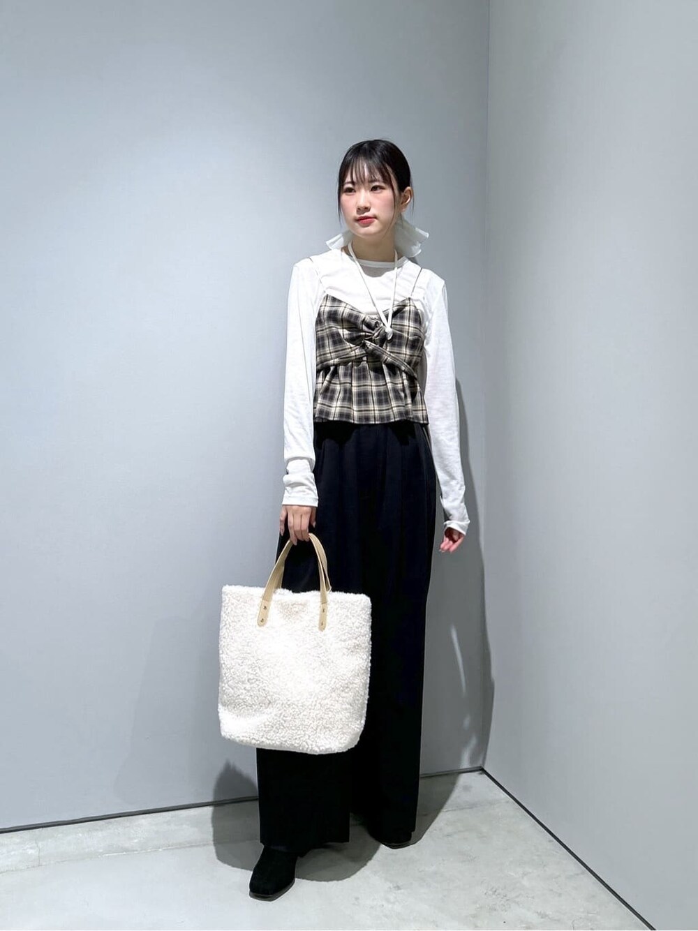 ベージュ系のタンクトップ、ホワイト系のTシャツ/カットソー、ブラック系のその他パンツを着用したレディースの冬コーディネートの2枚目の写真
