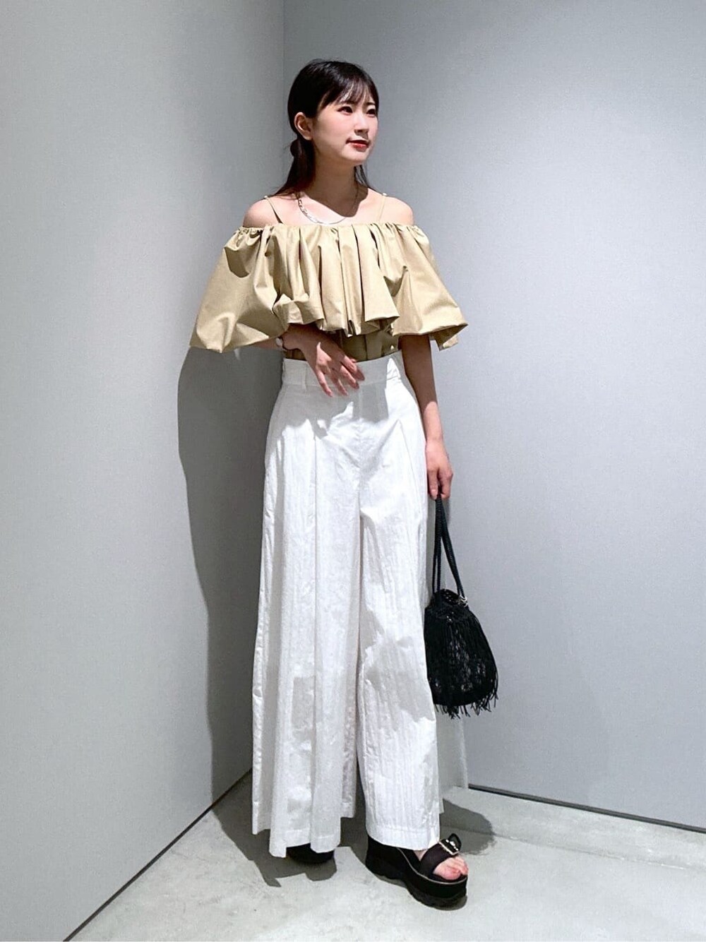 ベージュ系のシャツ/ブラウス、ホワイト系のその他パンツ、ブラック系のハンドバッグを着用したレディースの夏コーディネートの2枚目の写真