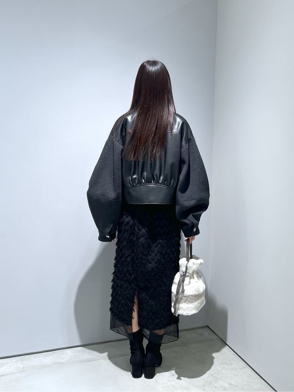 ブラック系のブルゾン、ブラック系のスカート、グレー系のショルダーバッグを着用したレディースの冬コーディネートの5枚目の写真